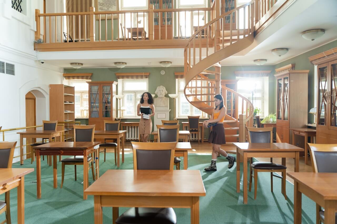 two women standing in a library